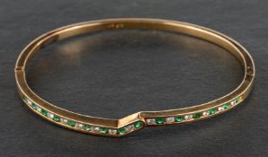 A round, mixed-cut emerald and round, brilliant-cut diamond hinged bangle,