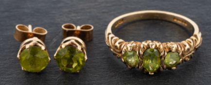 A 9ct gold, oval, mixed-cut peridot, three-stone ring and round, mixed-cut peridot ear studs,