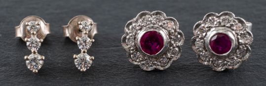 Two pairs of diamond earrings, including a pair of diamond three-stone earrings,