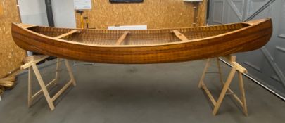 An early 20th century Canadian cedar strip canoe: of traditional construction with three seats,