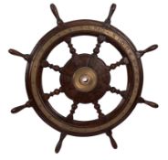 A WWI period teak and brass ship's helm: with block and turned spars,