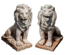 A pair of painted stone composition garden models of lions,