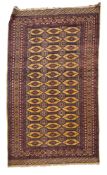 A Turkoman rug, the shaded wine geometric field with three rows of quartered guls,