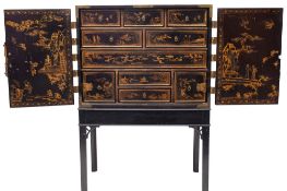 A Japanese black lacquered and parcel gilt cabinet on stand,