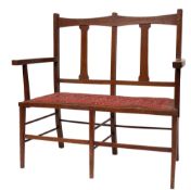An oak and upholstered settee in Arts & Crafts style,