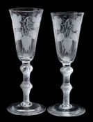 A pair of ale glasses engraved with hops and barley, on double knopped air twist stems, 20cm.