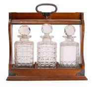 An oak and silver plated metal tantalus,