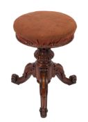 A Victorian carved walnut circular piano stool with an upholstered stuff over seat,