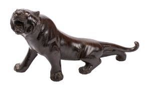 A Japanese patinated bronze model of a tiger with glass eyes,