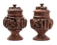 A pair of Eastern Asian 'dragon' jars and covers carved in high relief with mythical beasts, 22cm.