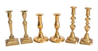 A pair of 19th century brass candlesticks with urn-shaped sconces of knopped stems and square bases