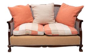 A mahogany and canework bergere sofa, early 20th century; with shallow arched back,