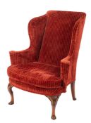 A Queen Anne carved walnut wing frame armchair fully upholstered in wine coloured moquette fabric