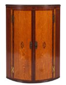 A George III oak and cross banded hanging corner cabinet,