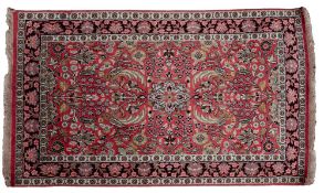 A Kashmir silk rug, the rose field with a design of palmettes and flowering stems,