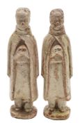 A pair of Chinese pale celadon glazed terracotta funerary figures each modelled standing with