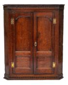 A George III oak hanging corner cabinet,