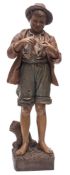 A Friedrich Goldscheider pottery figure, of a young barefoot boy in jacket, shorts and hat,