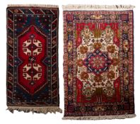 An Afghan Belouch rug, the red pointed field with ivory twin geometric medallions,