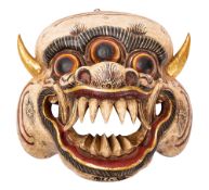 A Nepalese carved and painted wood face mask in the form of a demon, 25cm wide.