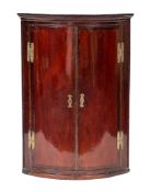 A George III mahogany hanging corner cabinet,