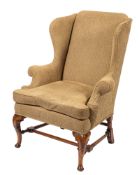 A carved walnut wing frame armchair in the Queen Anne taste,