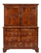An early 18th Century walnut cabinet on chest, the upper part with a moulded cornice,