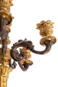 A pair of French patinated and parcel gilt bronze six light candleabra, in Neoclassical style,