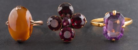Three gemset rings, including a garnet ring of flowerhead design,