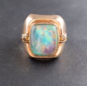 A cabochon-cut opal doublet ring, the shoulders probably set with topaz, stamped '9CT',
