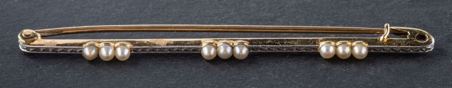 An early 20th century, seed pearl bar brooch, stamped '15CT', total length ca. 6.