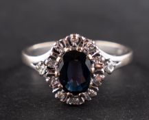 An 18ct gold, oval, mixed-cut sapphire and single-cut diamond cluster ring,