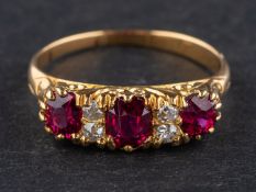 An 18ct gold, oval, mixed-cut ruby ring, with single-cut diamond spacers,