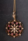 A circular, openwork pendant, with floral motif, set with seed pearls and probably pink tourmaline,