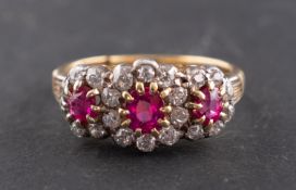 An oval, mixed-cut ruby and diamond, triple cluster ring, total estimated diamond weight ca. 0.