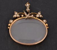 A magnifying glass pendant, set with seed pearls in a floral design with swallow motif,