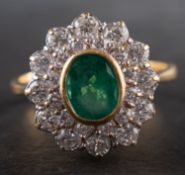 An 18ct gold, oval, mixed-cut emerald and round, brilliant-cut diamond cluster ring,