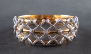 A mid-20th century, diamond-set, hinged bangle, of lattice design,