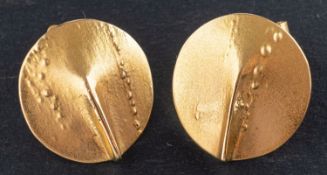 A pair of circular, textured ear studs, designed with a fold, stamped '750', with post fittings,