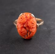 A carved coral ring, depicting a rose spray, stamped '9CT', length of ring head ca. 1.