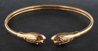A ruby and white paste, double-headed snake bangle, stamped '585', inner diameter ca. 6.