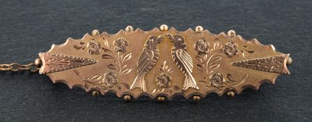 An oval brooch, with scalloped edges, depicting a pair of doves, stamped '9C', total length ca. 4.