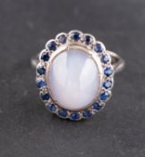 An oval, cabochon-cut, grey, star sapphire and sapphire cluster ring,
