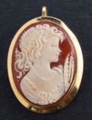 A shell cameo brooch/ pendant, depicting the bust of a lady, stamped '750', total length (inc.