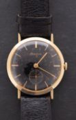 Bulova, a gentleman's 14K gold wristwatch the black dial having gold baton numerals and hands,
