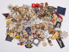 A quantity of British and world regimental cap badges and insignia.
