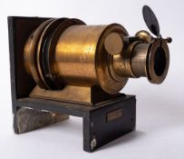 A lacquered brass 6 inch Magic Lantern lens on and ebonised base,