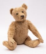 An early 20th-century Steiff blond plush Teddy bear, with button to ear, black boot button eyes,