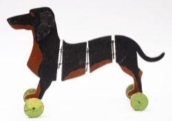 A mid 20th century wooden articulated Daschund on wheels,