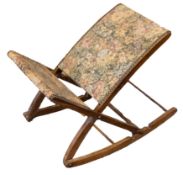 An oak folding gout stool with tapestry upholstery.